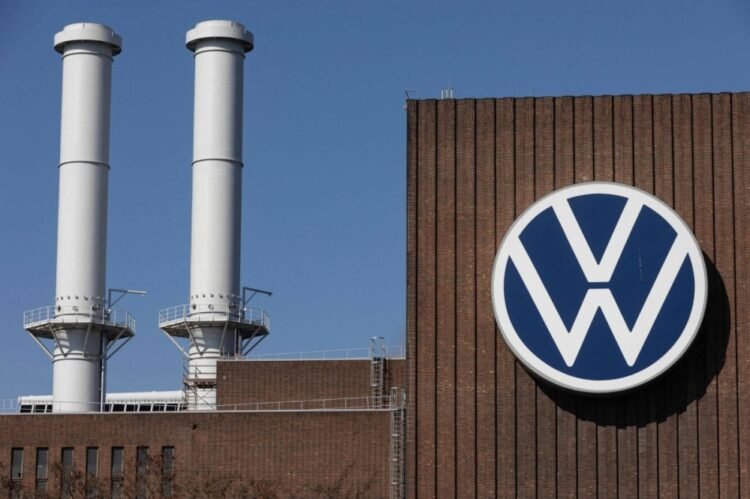 (FILES) The logo of German carmaker Volkswagen (VW) is pictured on the main plant of the group in Wolfsburg, northern Germany, on March 22, 2022. German automotive giant Volkswagen said on September 2, 2024 it could close production sites in Germany, as the auto industry struggled to manage rising costs. (Photo by Yann Schreiber / AFP)